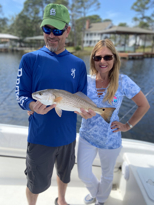 Husband and wife caught a redfish with Captain Nick at Scallywag Charters
