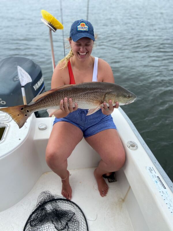 Estatic girl catching her first red fish with Scallywag Charters